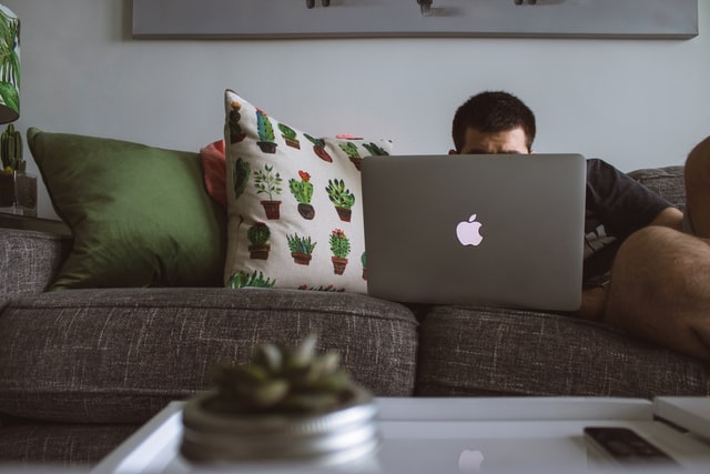 Image showing someone watching their laptop while lounging on a couch.